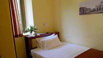 Enjoy a peaceful retreat with a comfortable bed, a small table, and a beautiful painting on the wall.
