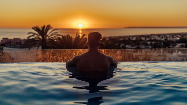 A person in a swimming pool with a sunset view. - Hotel El Cortijo De Zahara by Q Hotels (Tarifa)