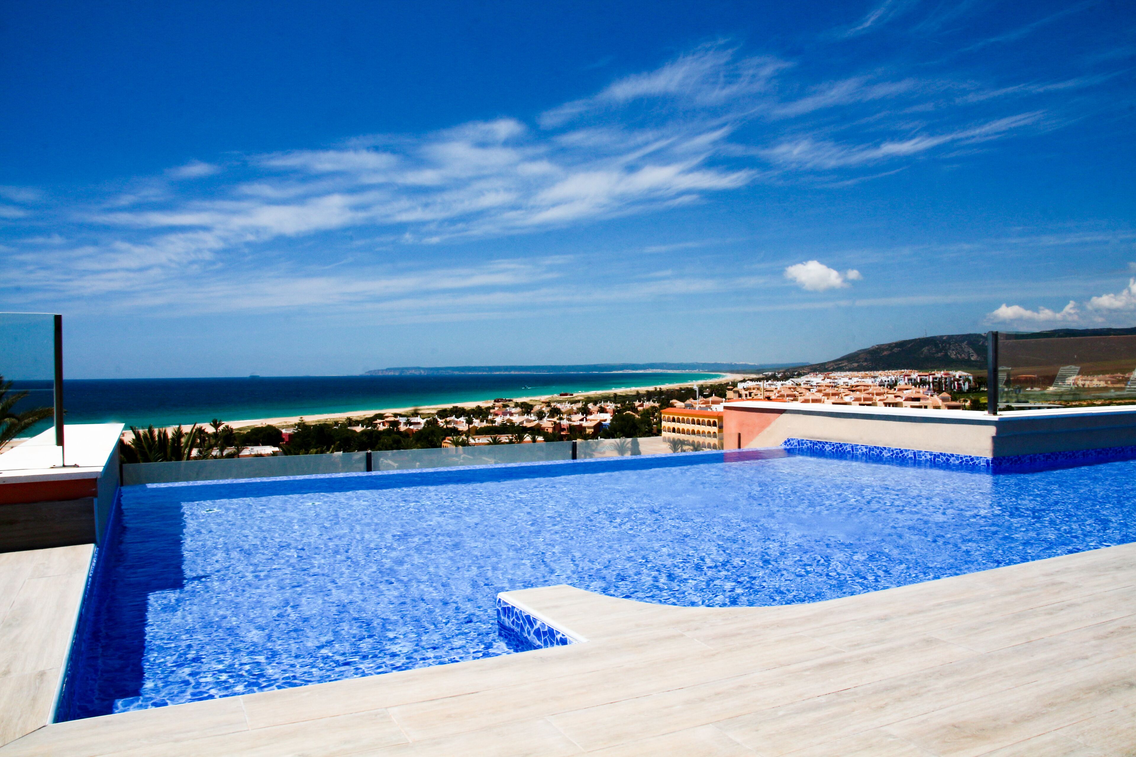 An infinity pool with a clear view of the beach and ocean.