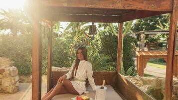 A wooden structure with a bench, a glass of wine, and a plate of food.