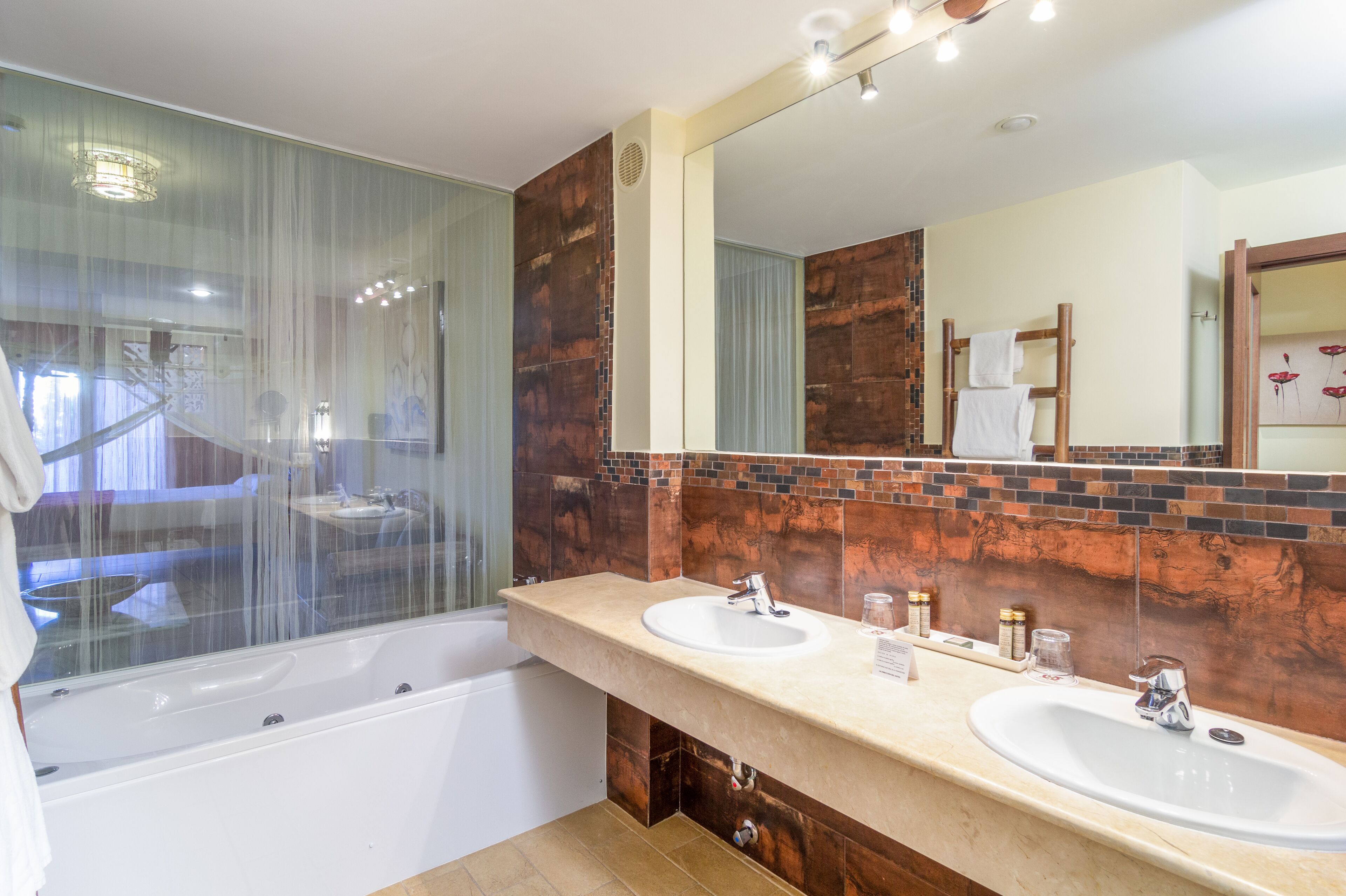 A modern bathroom with a glass-enclosed shower, two sinks, and a large mirror.