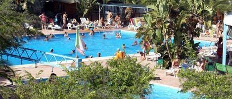 Een buitenzwembad, zwembadcabana's (toeslag) en ligstoelen