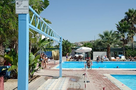 Una piscina al aire libre, camas de piscina con cargo