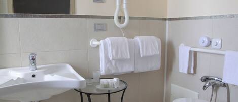 A bathroom with a sink, toilet, and towel rack.
