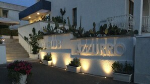 Fachada d'edifici amb el nom "LAZURRO" il·luminat.