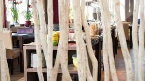 A buffet area with a variety of food items and a seating area with a view of the outdoors.