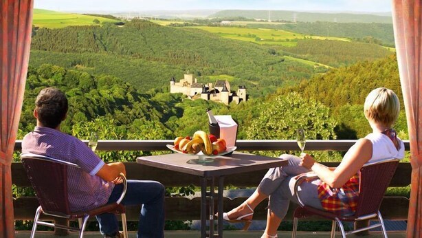 Two people seated at a table with a view of a castle in the distance.