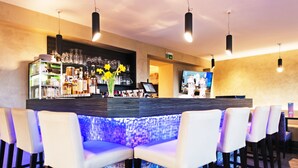 A bar area with a counter, bar stools, and a display of liquor bottles.