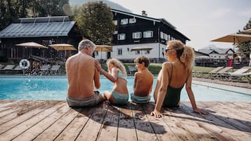 En sÀsongsöppen utomhuspool, parasoller och solstolar