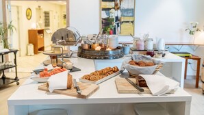 A buffet setup with various food items, including pastries and fruits, arranged on a counter. - Vilcon Hotel & Konferencegaard (Slagelse)