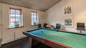A pool table with a ball, two windows with plaid curtains, and two framed pictures on the wall. - Vilcon Hotel & Konferencegaard (Slagelse)