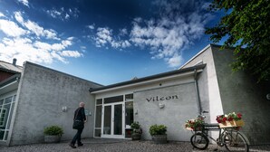A building with a sign reading "Vilcon" and a bicycle with a basket of flowers parked in front. - Vilcon Hotel & Konferencegaard (Slagelse)