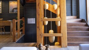 A wooden staircase with a rope and basket hanging from it, a wooden bench, and a small table with a plant. - Refugio Knapp (San Carlos de Bariloche)