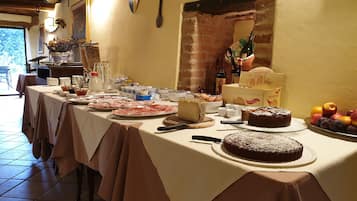 Ein reichhaltiges Buffet mit verschiedenen Speisen, darunter Fleisch, Käse und ein Kuchen.
