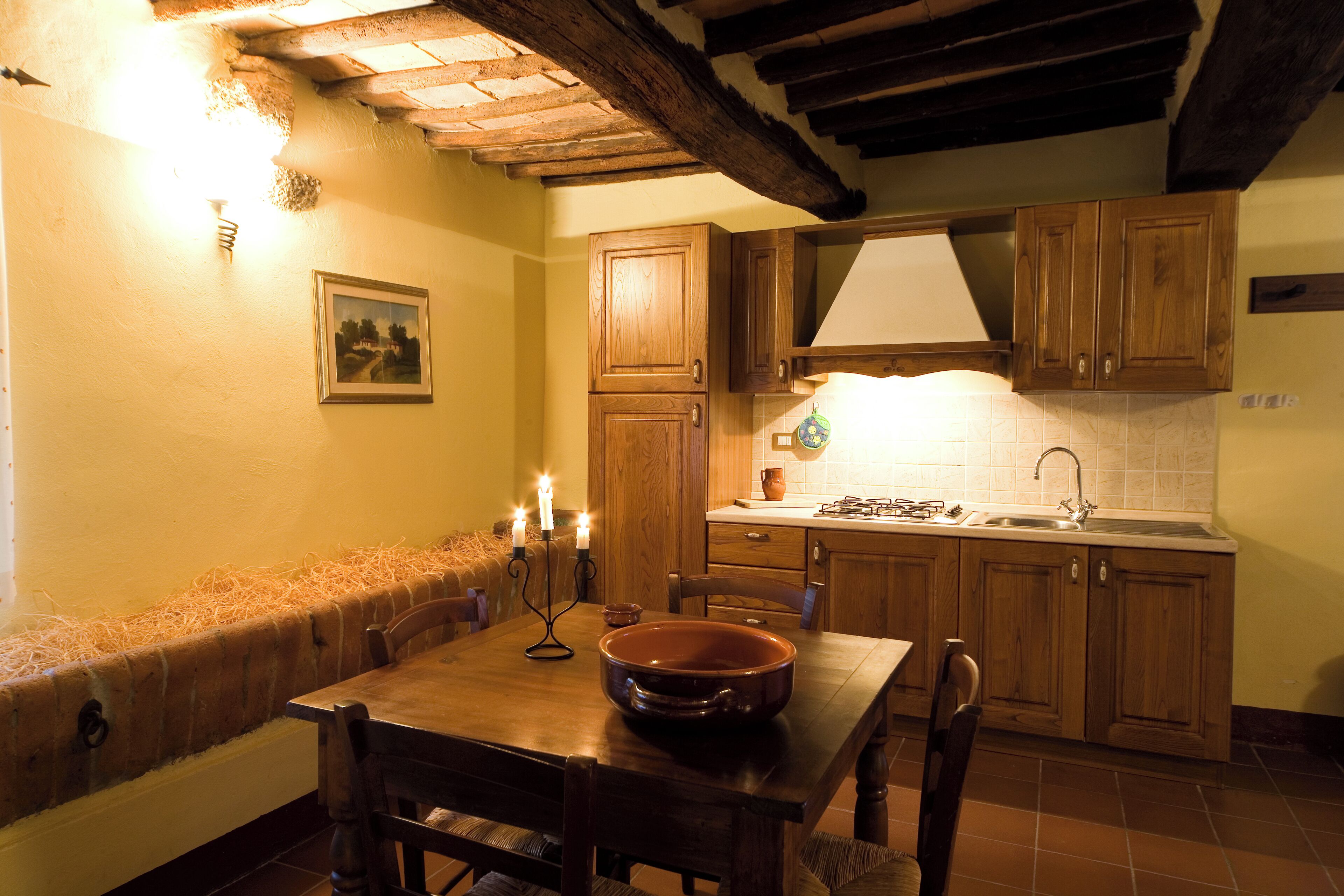 A cozy kitchen with wooden cabinets, a dining table, and a built-in bench.