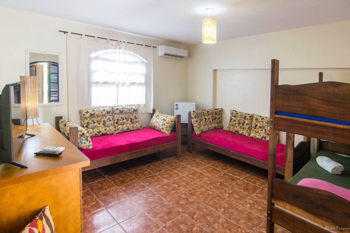 A room with two bunk beds, a desk with a computer, and a window with curtains.