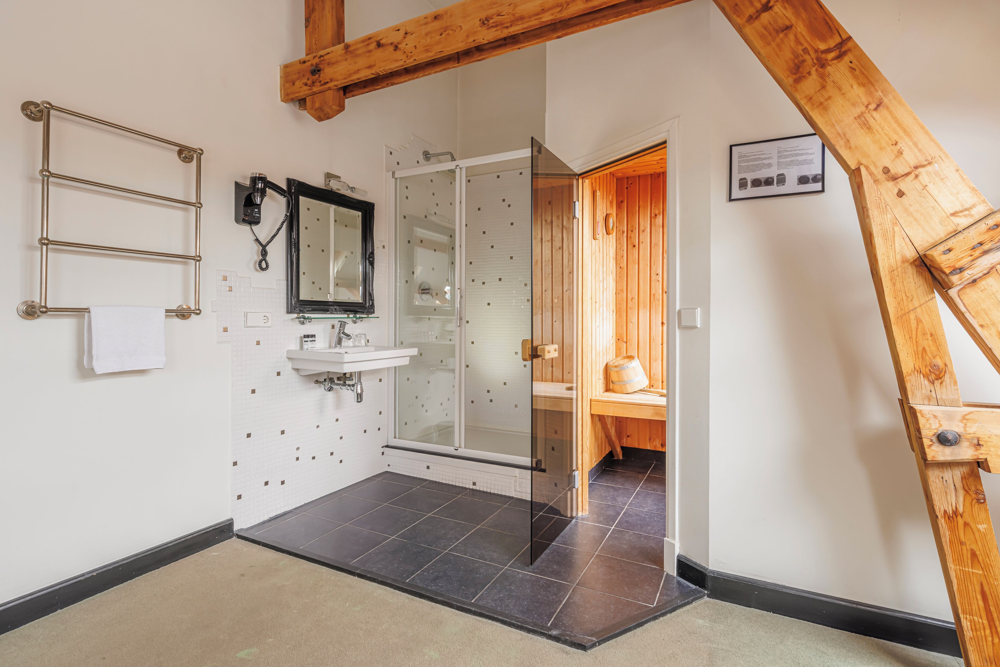 Une salle de bain avec une douche, un lavabo et un porte-serviettes.