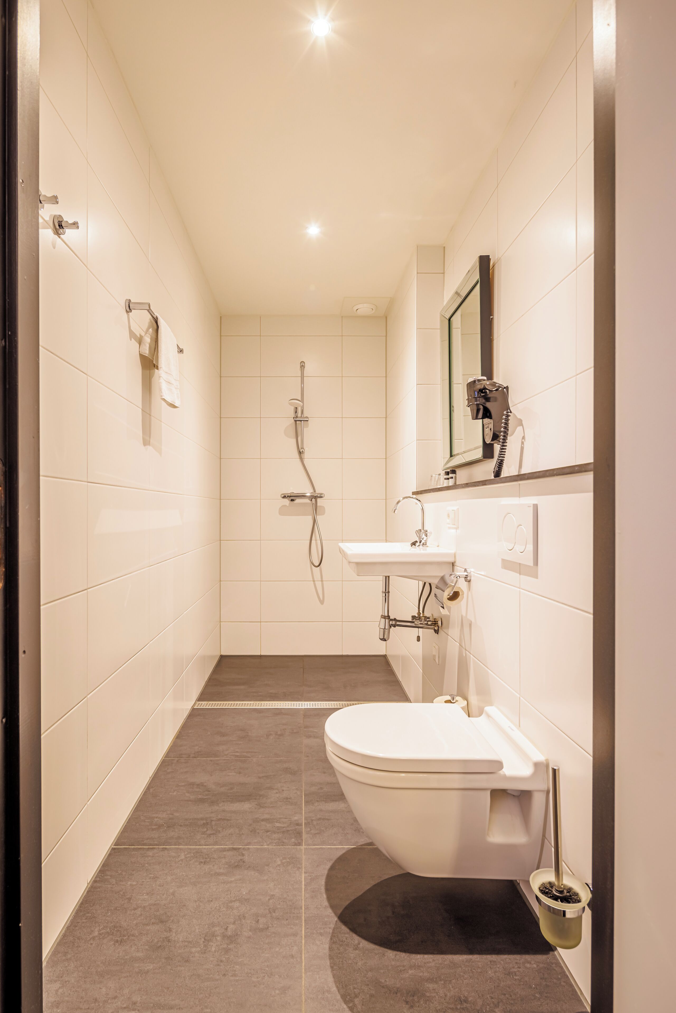 A modern bathroom with a toilet, sink, and shower.