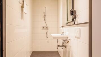 A modern bathroom with a toilet, sink, and shower.