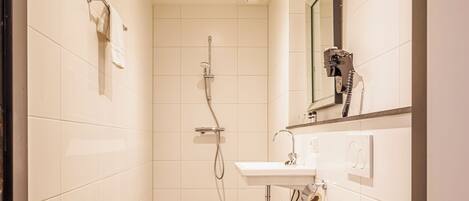A modern bathroom with a toilet, sink, and shower.