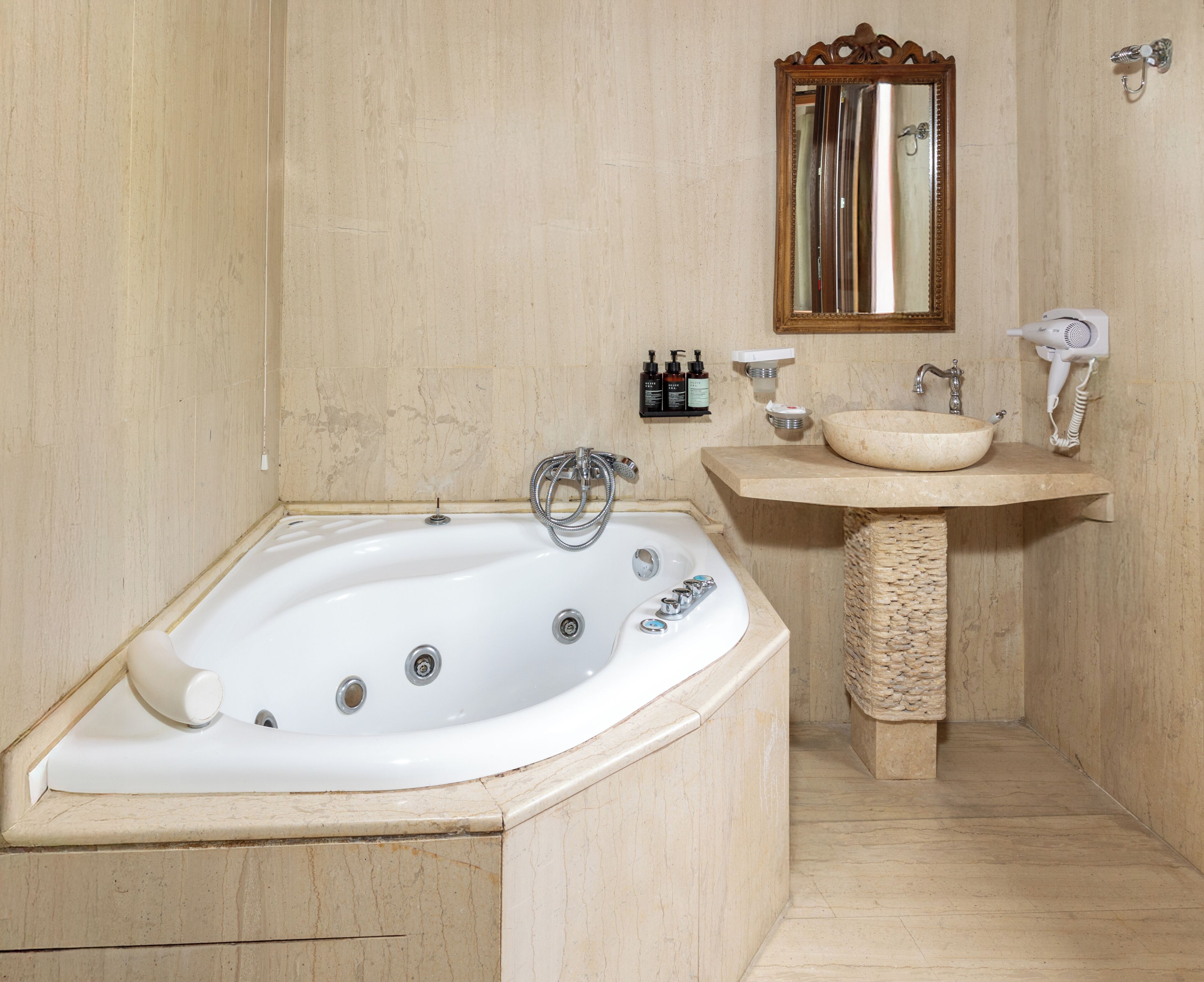A bathroom with a freestanding bathtub, a vanity with a bowl sink, a mirror, and a hairdryer.
