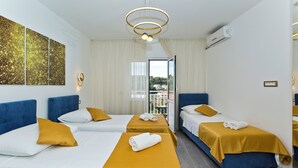 Habitació d'hotel amb dos llits, una finestra gran i vista a la ciutat.