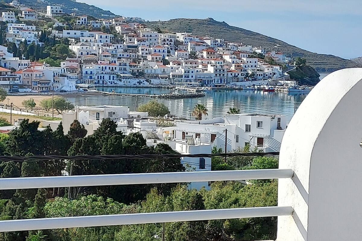 Un pueblo costero con edificios blancos, un puerto y una ladera.