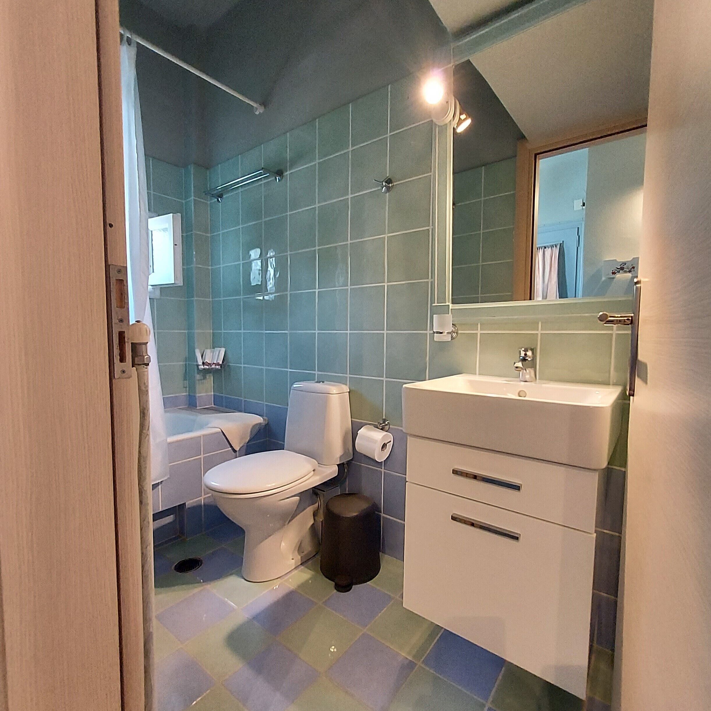 Un baño con inodoro, lavamanos y espejo.