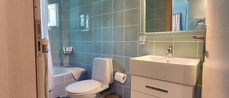 Un baño con inodoro, lavamanos y espejo.