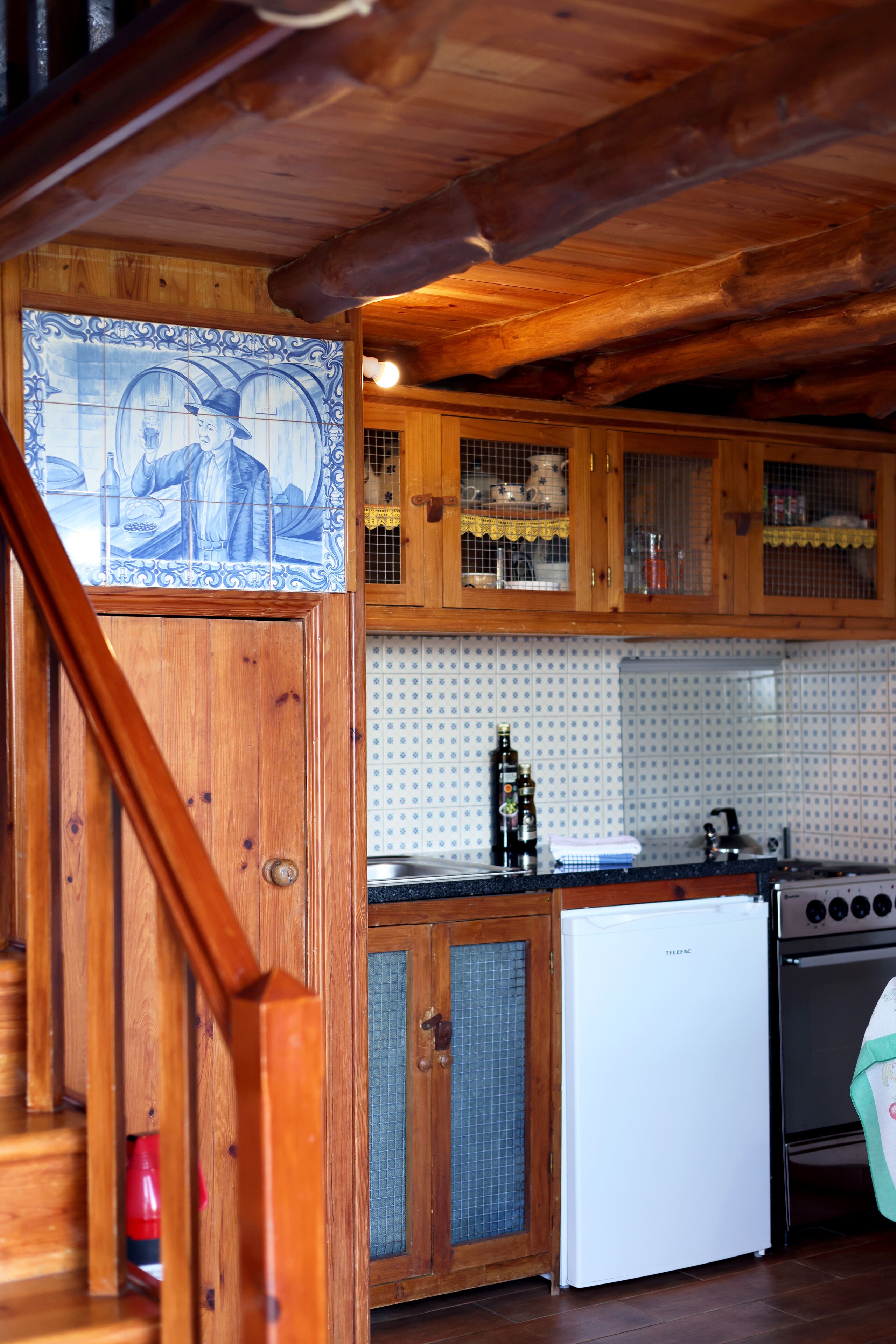 Una cocina con armarios de madera, un refrigerador blanco y una estufa.