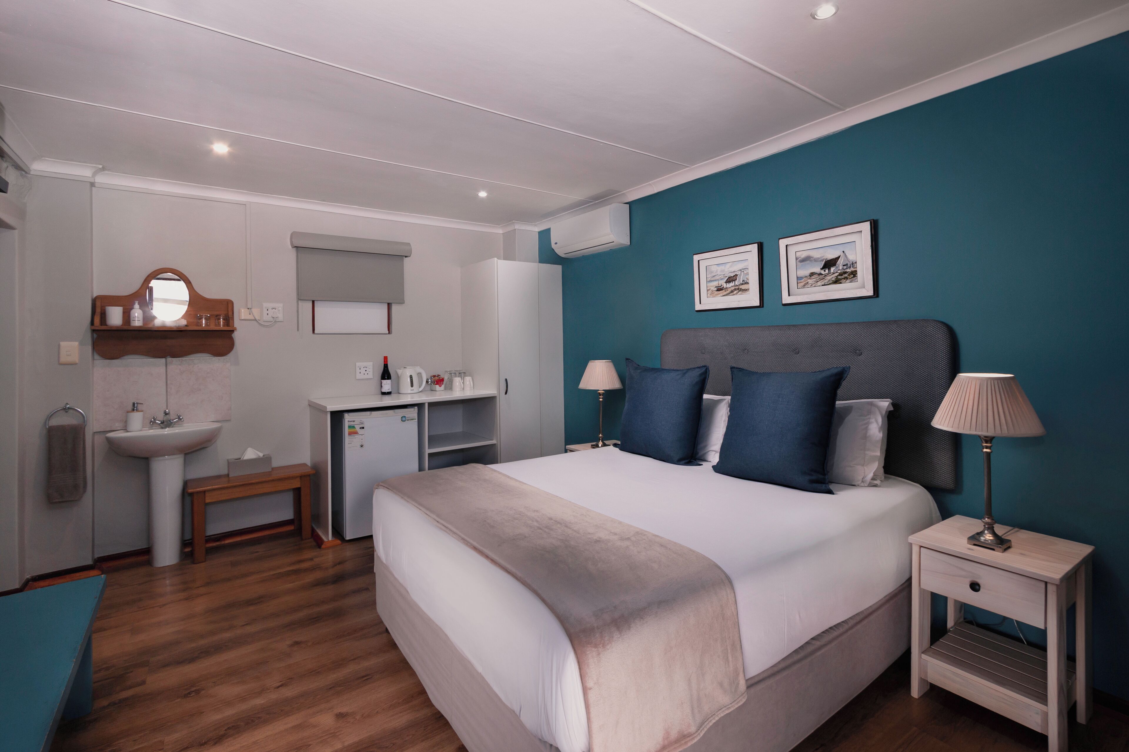 Une chambre à coucher comprenant un lit, une table de chevet, une lampe et un petit bureau avec une chaise.