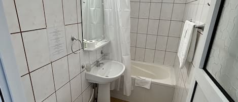 Un baño pequeño con inodoro, lavabo y bañera.
