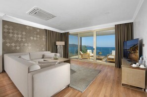 Suite Grand, 1 cama de matrimonio, cocina básica, vistas al mar | Zona de estar | Televisión LCD de 65 pulgadas con canales por satélite, una televisión