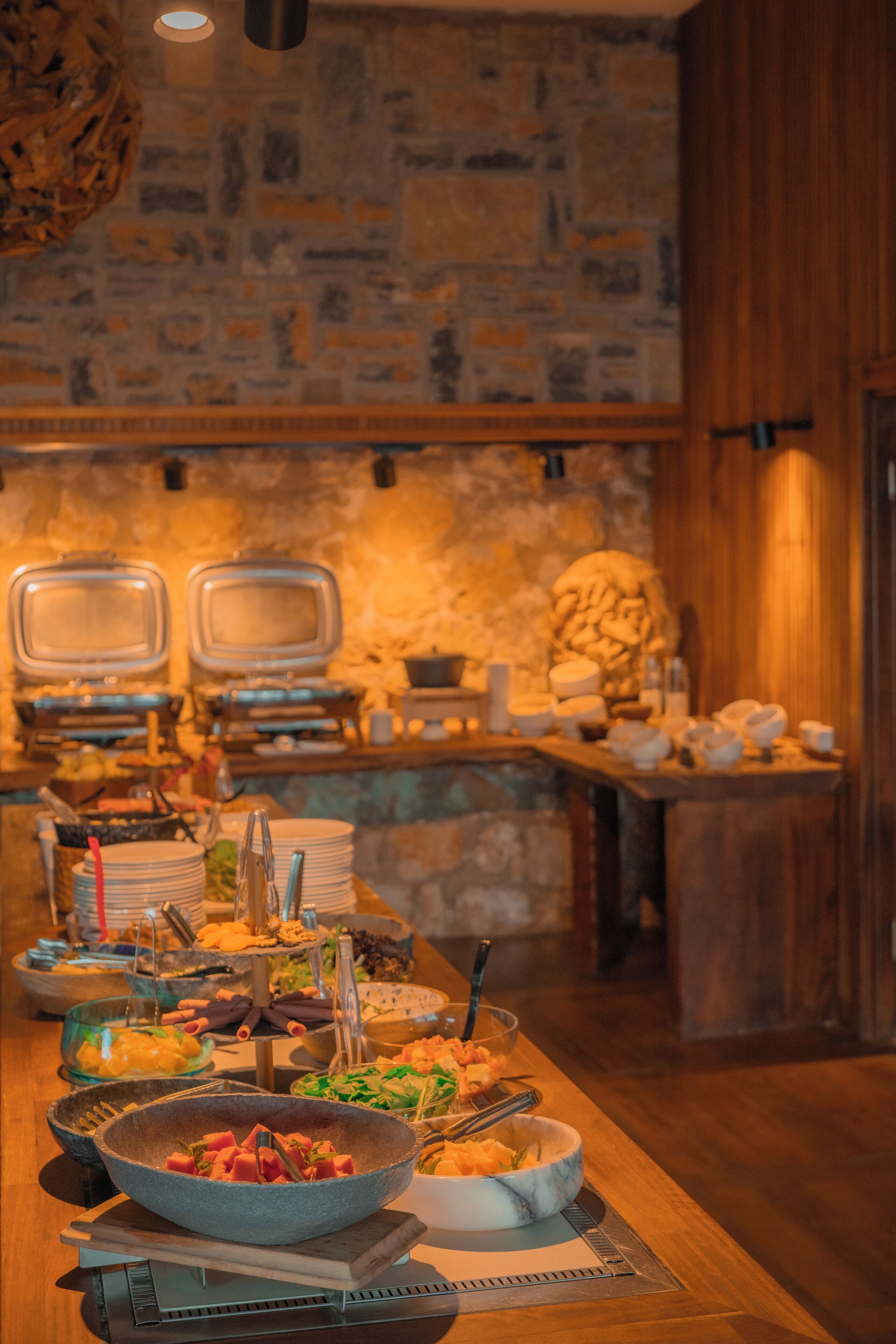Ein reichhaltiges Buffet mit verschiedenen Speisen und Geschirr, eine Steinsäule und Holzschränke.