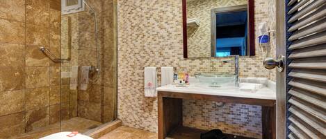 A bathroom with a glass shower enclosure, a white toilet, a sink with a mirror, and a towel rack.