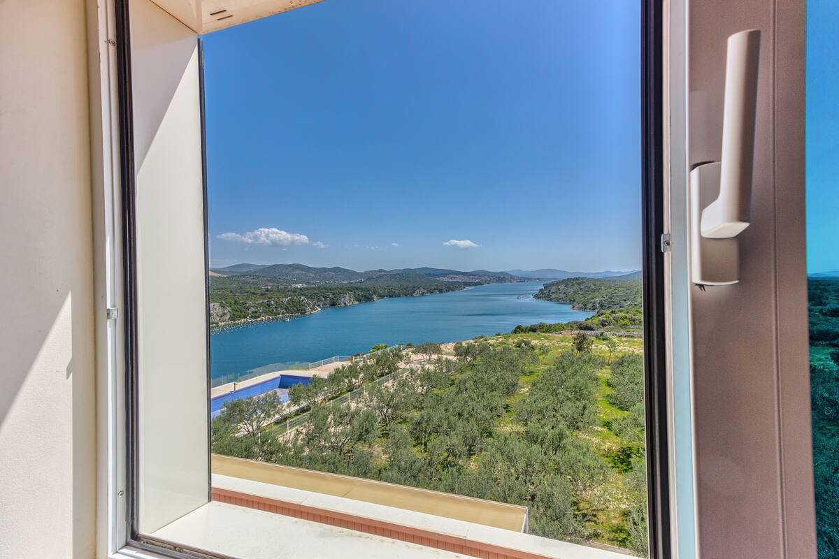 A view from a balcony overlooking a lake with mountains in the distance.
