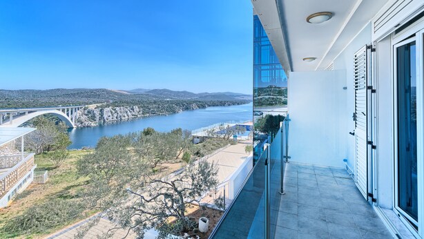 A balcony with a view of a bridge over a river, a clear sky, and a distant landscape. - Hotel Panorama (Sibenik)