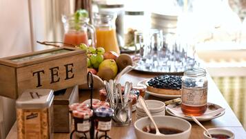 A breakfast buffet with various food items, utensils, and a sign labeled "TEE".