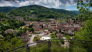 A town with historic buildings, a church, and a river. - Hotel Deybach (Munster)