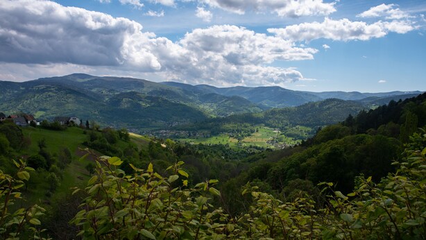 A mountainous landscape with a valley and a town in the distance. - Hotel Deybach (Munster)