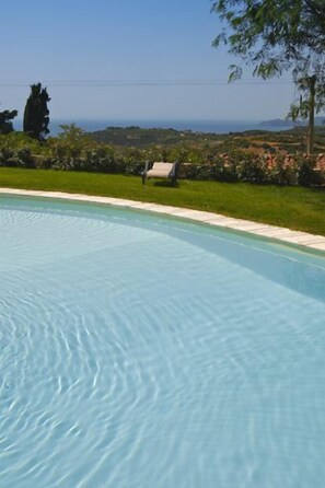 En säsongsöppen utomhuspool och solstolar