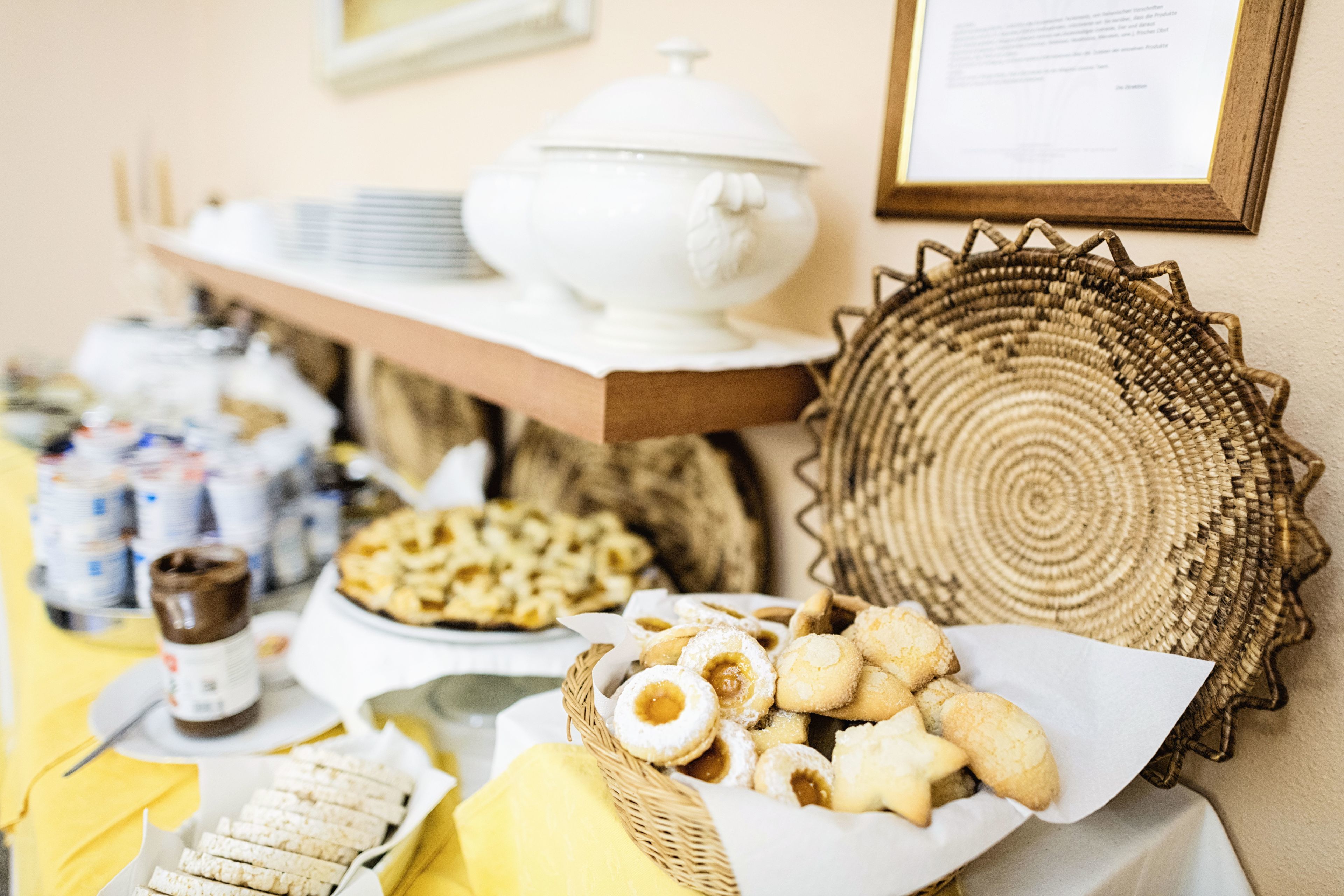 Un tavolo per buffet con diversi cibi, una zuppiera bianca e un cesto in vimini.