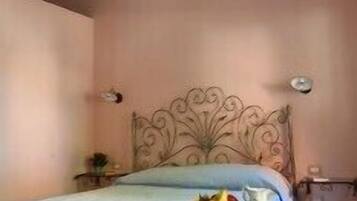 A bedroom with a bed, a bedside table, and a nightstand.