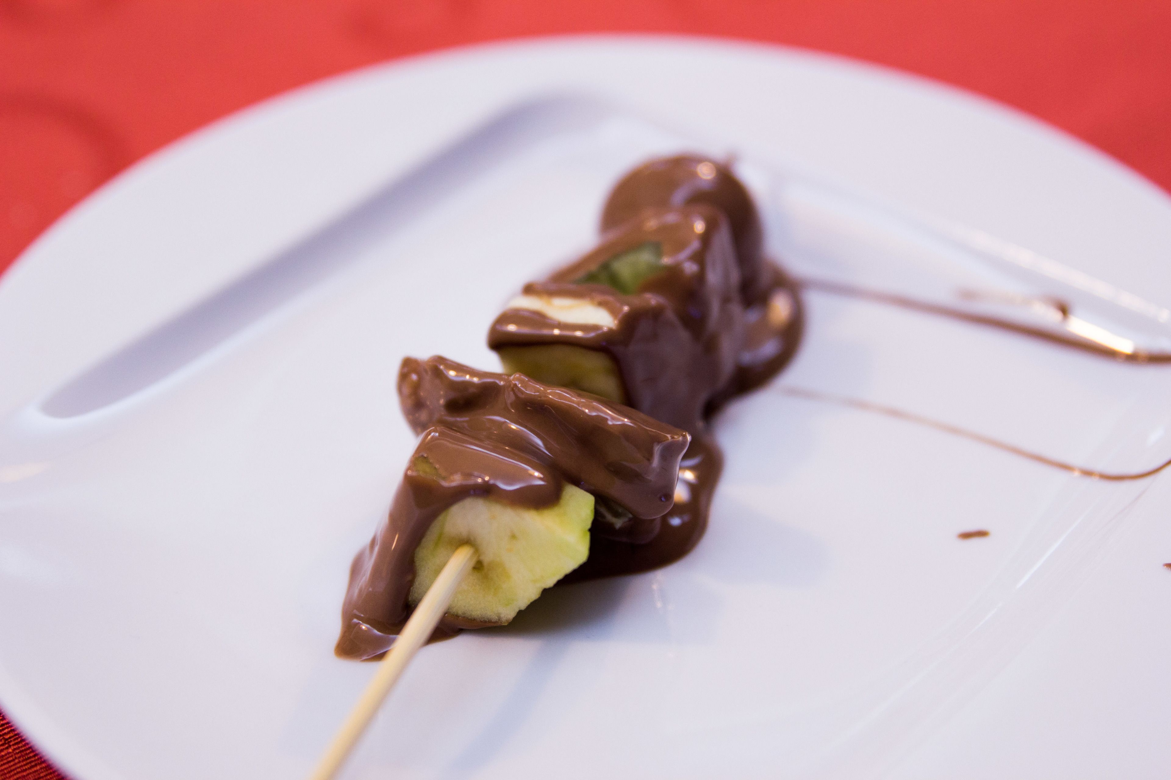 A dessert on a white plate with chocolate sauce.