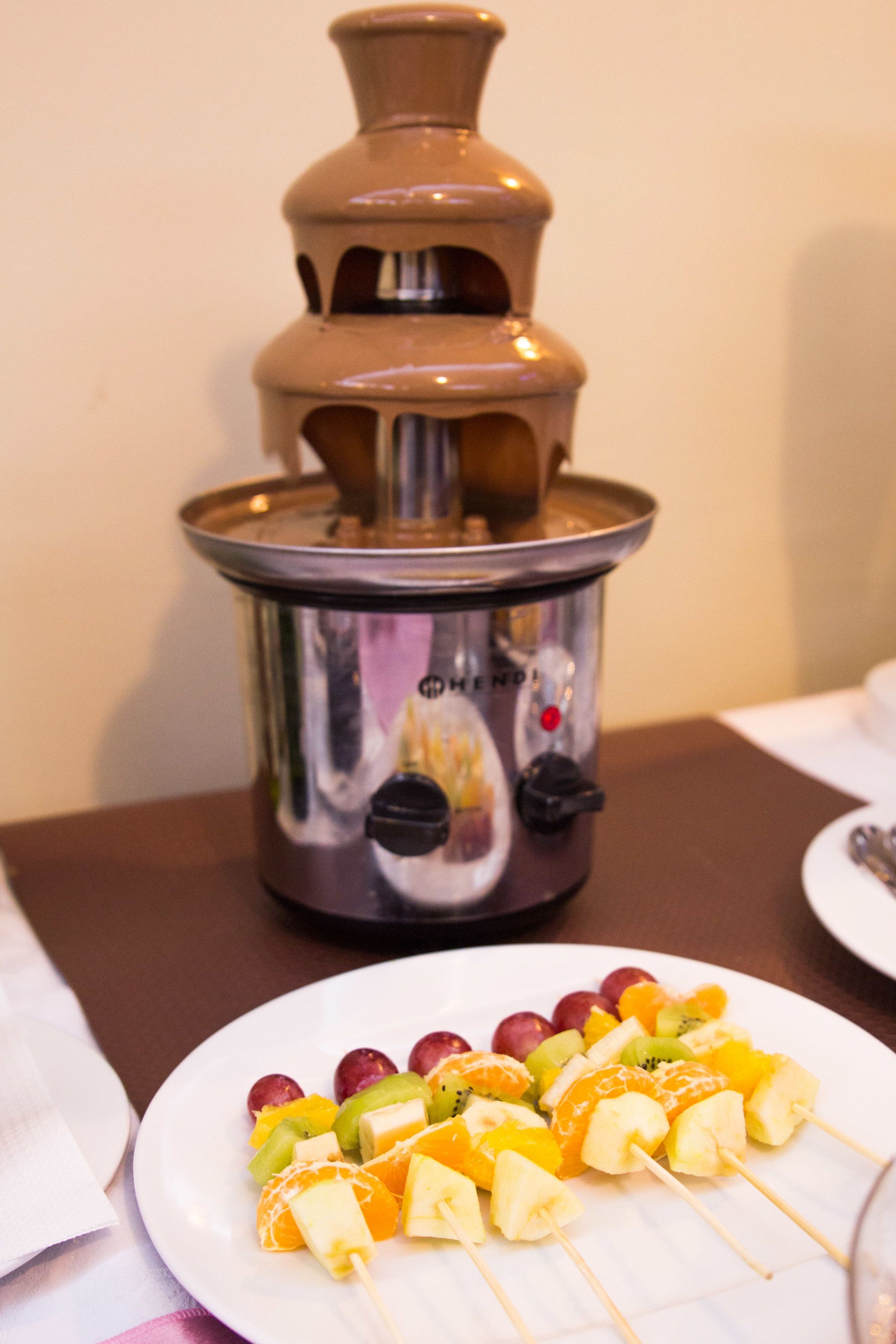 A kitchen area with a stove and a plate of fruit skewers.