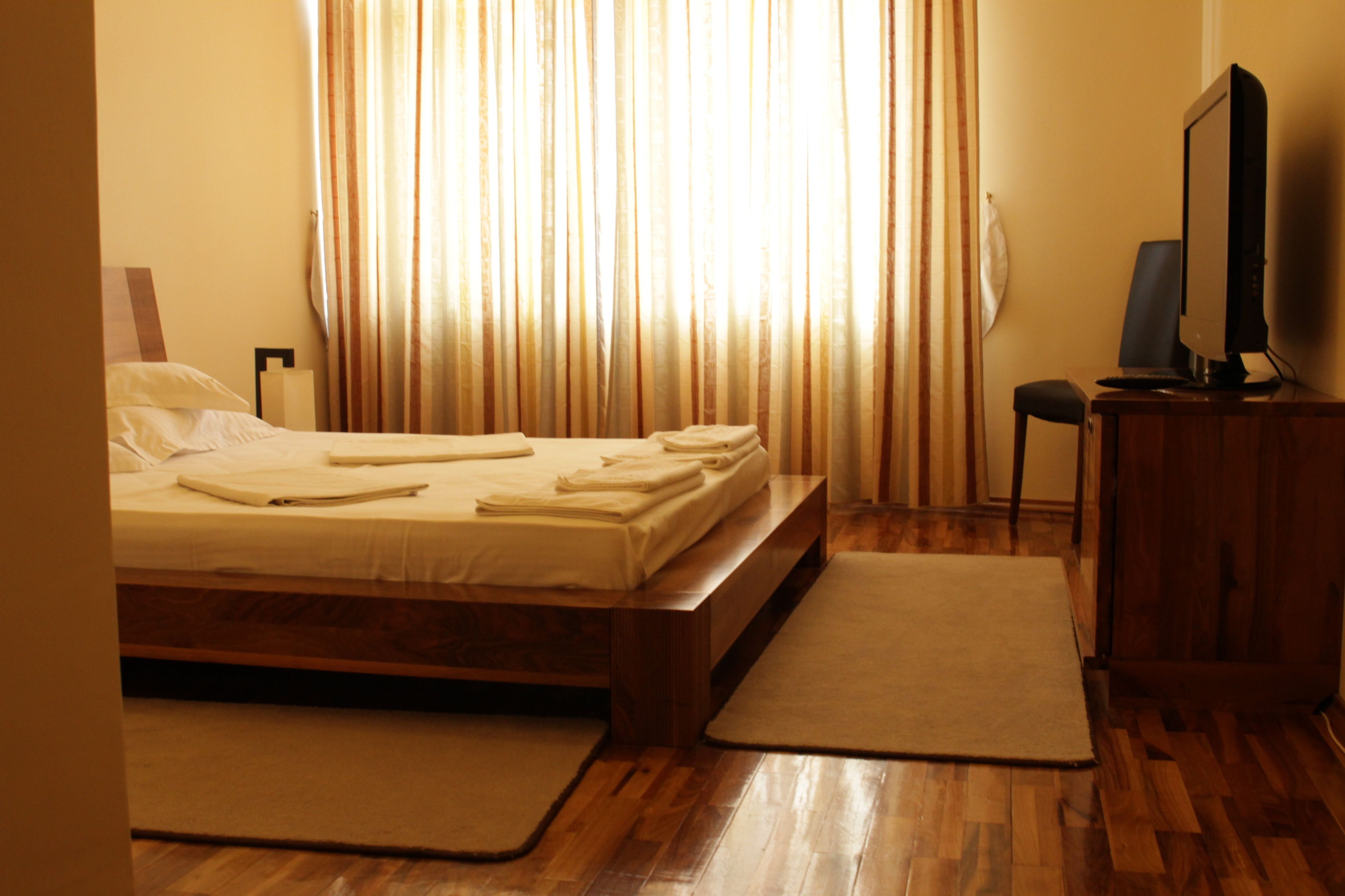 Habitación de hotel con cama, escritorio, silla y televisión.