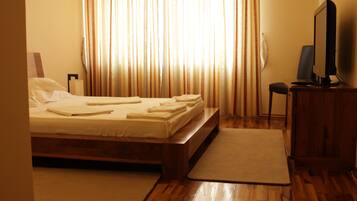 Habitación de hotel con cama, escritorio, silla y televisión.