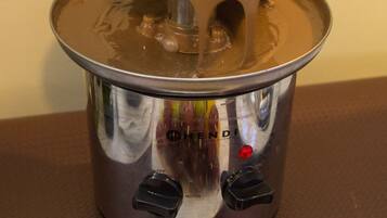 A fondue set with a pot and a smaller pot on a table.