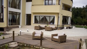 Un hôtel doté d’une terrasse, d’un chemin en pierre et d’un petit élément décoratif aquatique.