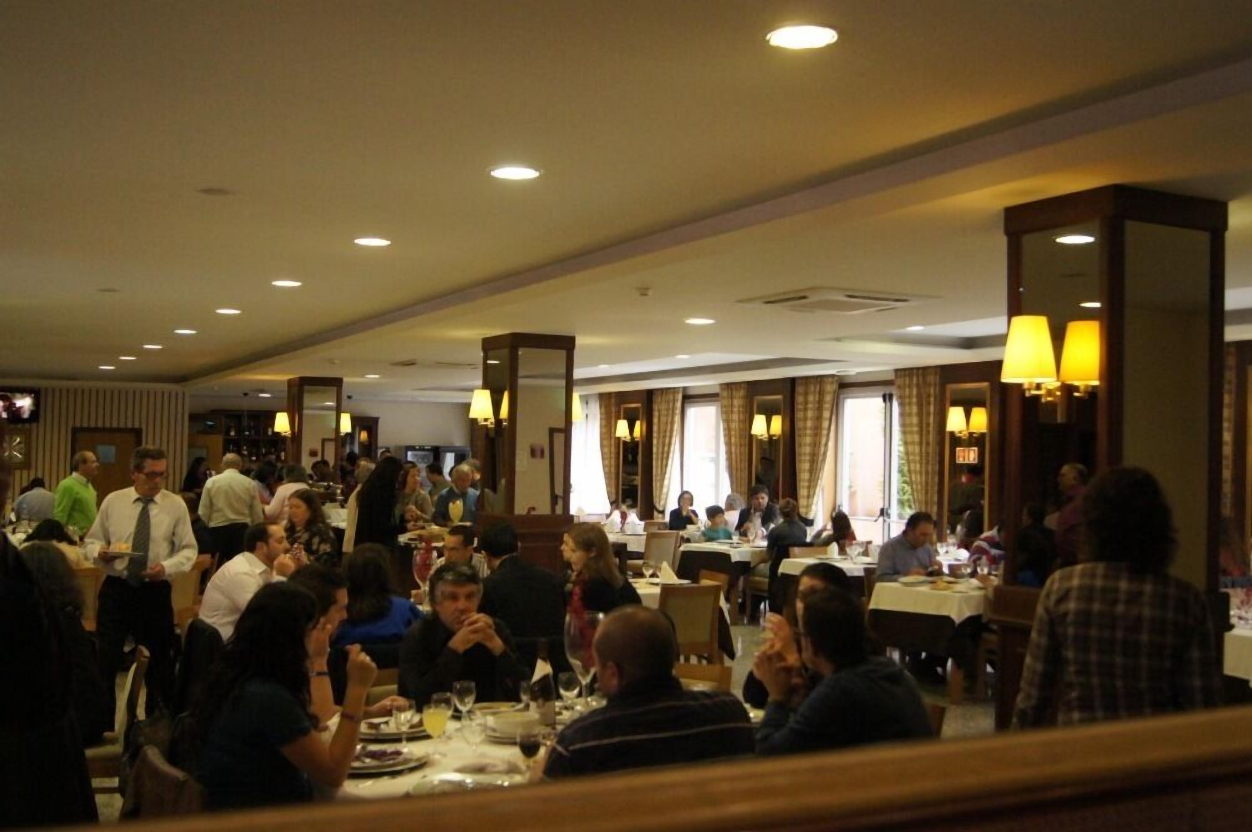 A busy hotel dining area with multiple tables and patrons.